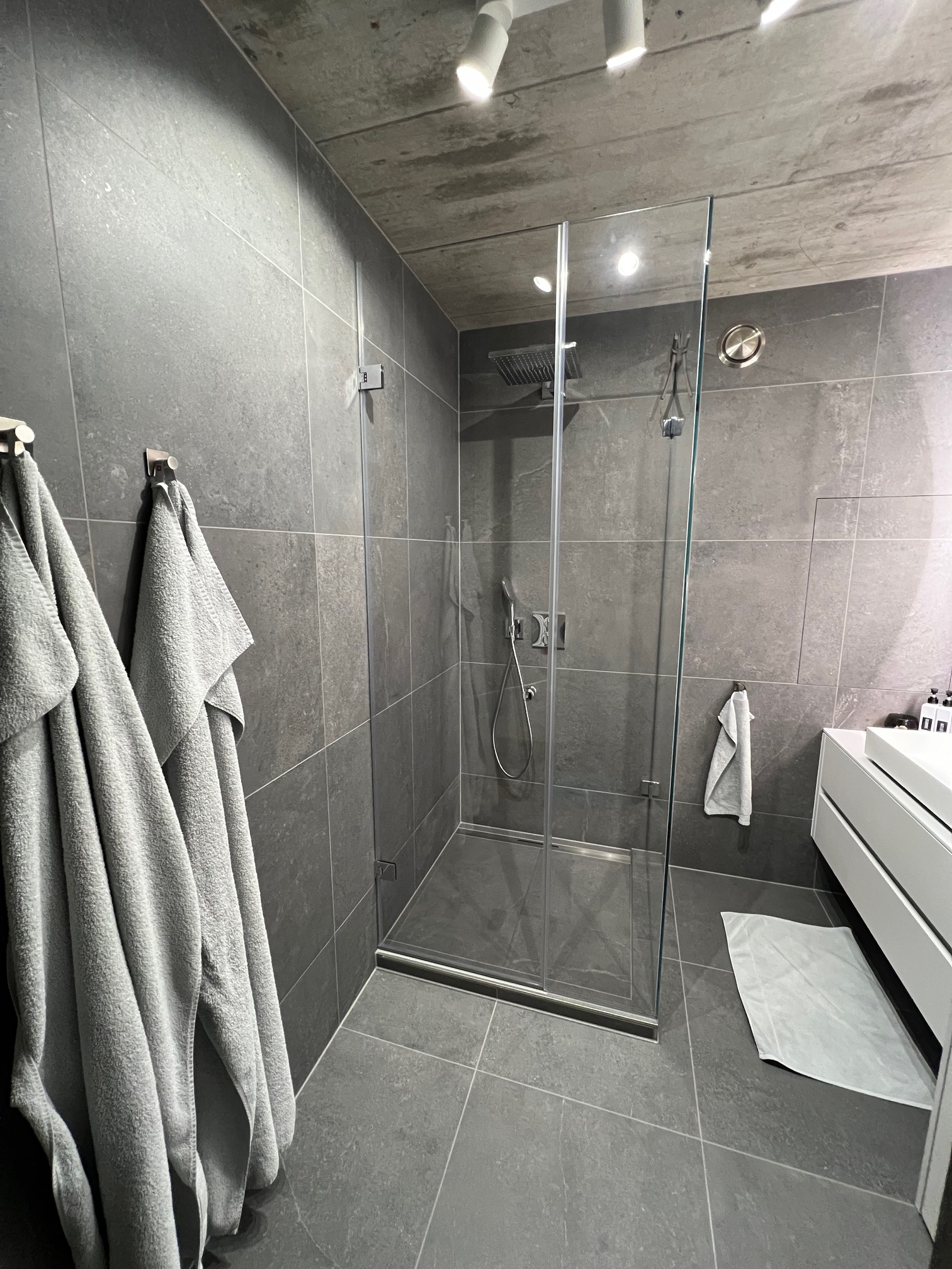 Fertiges Bad mit grauen Platten und Walk-in-Dusche