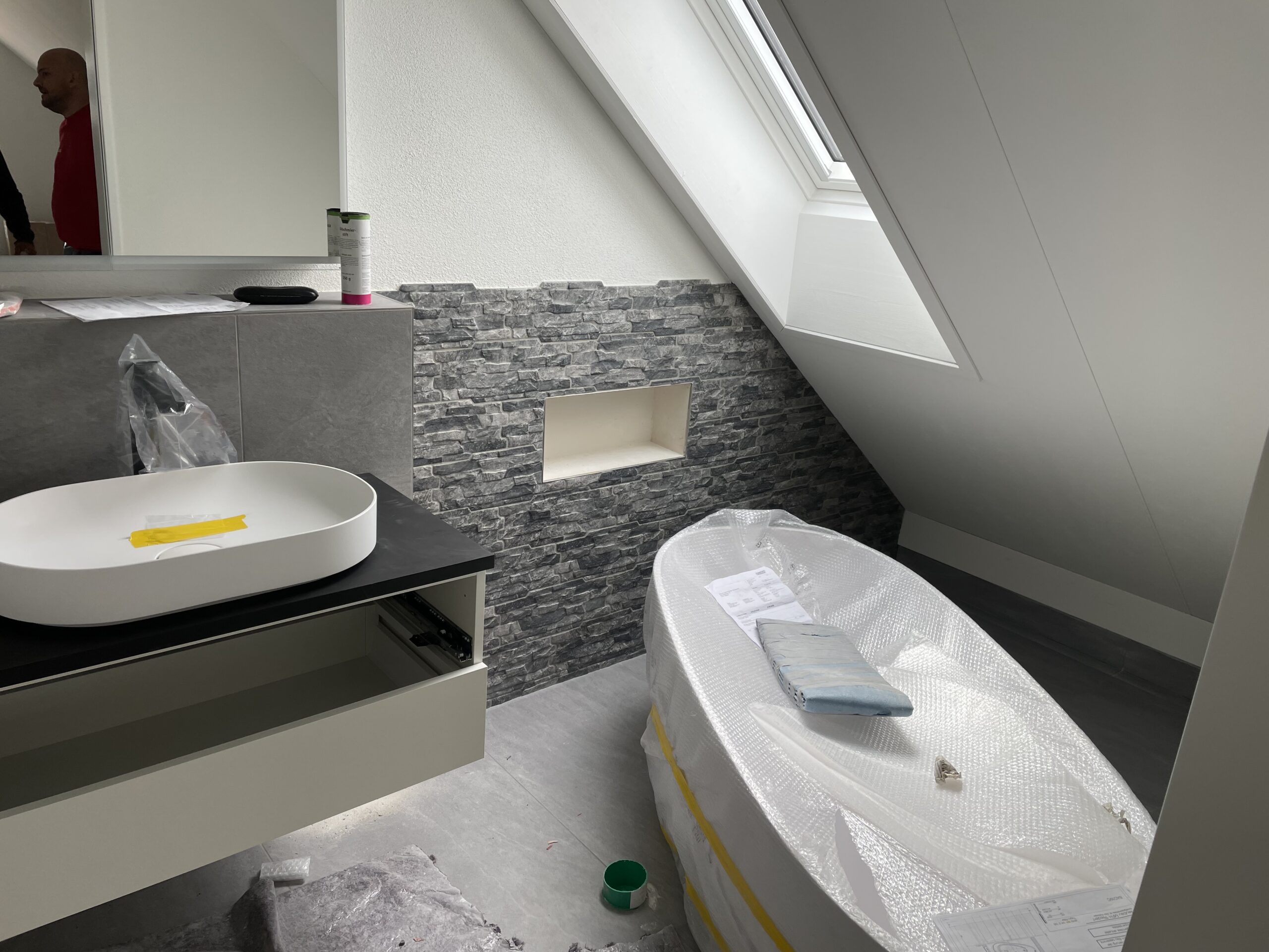 Dachgeschoss-Bad mit Steinstreifen-Wand und freistehender Wanne