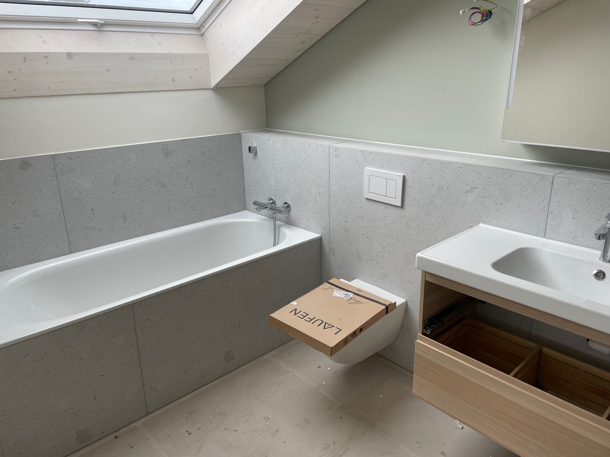 Hellgraues Dachgeschoss-Bad mit Badewanne