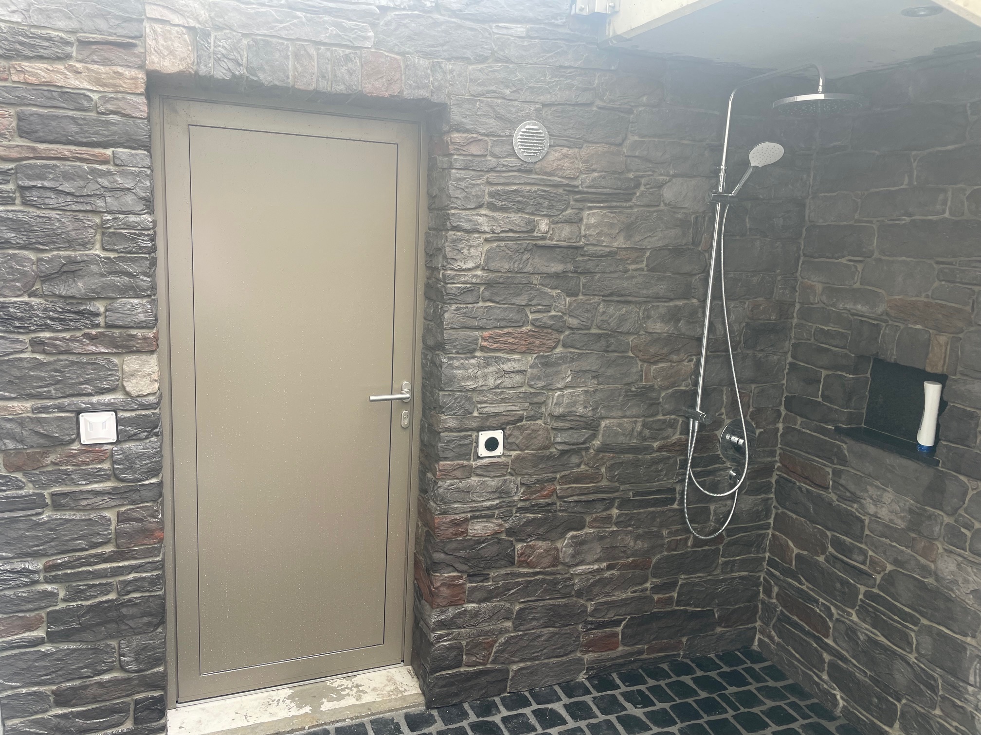 Dusche mit Natursteinwand