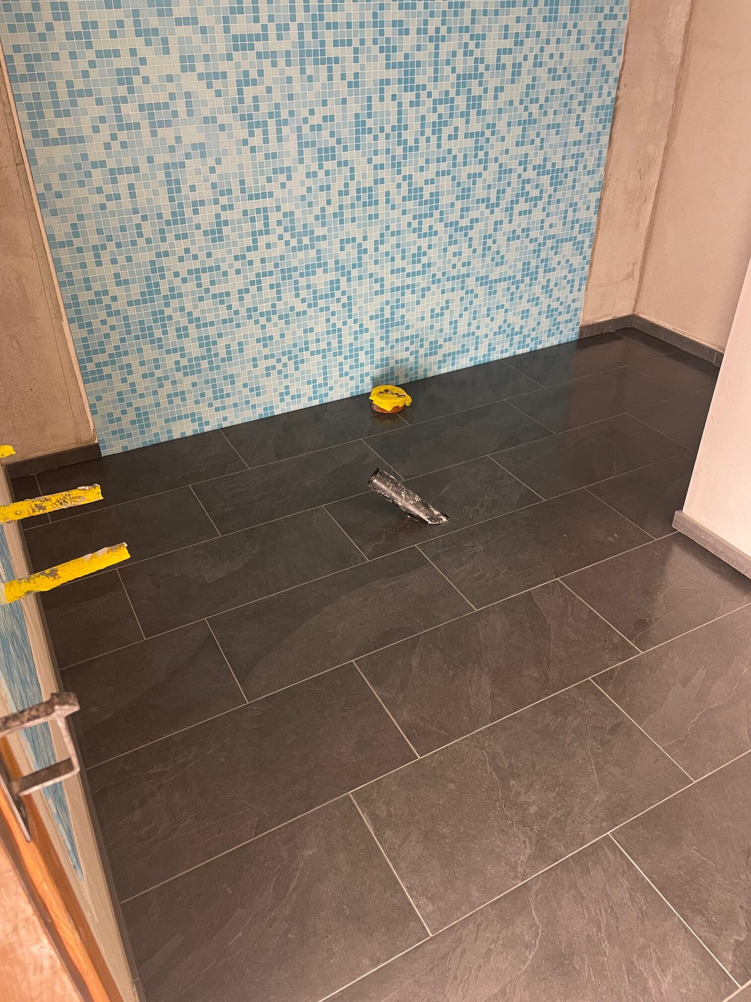 Blaue Mosaikwand und dunkler Boden während der Arbeiten